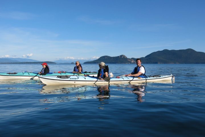 group of people kayaking on calm water